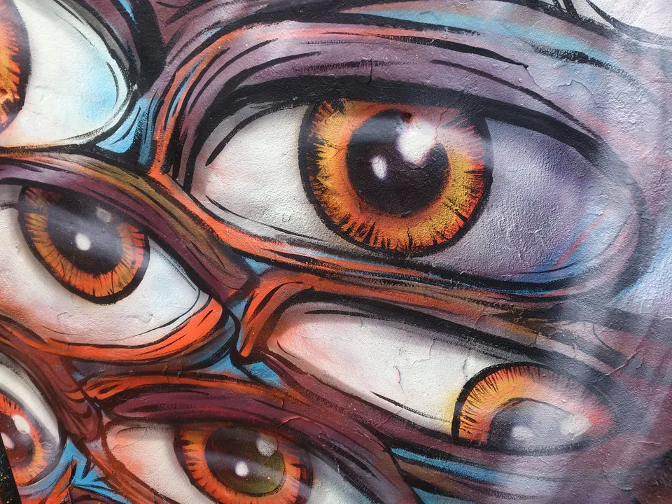 Psychedelic mural of overlapping orange eyes with bold black outlines