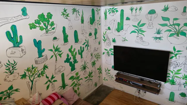 Office wall mural of green plants potted in black line-drawn everyday objects like a toaster, piggy bank and shoe