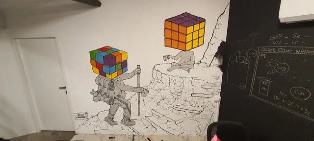 Mural of two line-art figures with colored Rubik's cube heads holding mugs in a rocky landscape