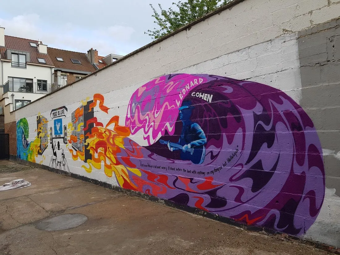 Long outdoor mural featuring a blue silhouette of Leonard Cohen playing guitar amidst purple waves and orange flames
