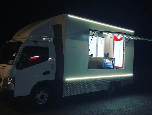 Blank white box truck parked at night with an open serving window, lit interior and exterior LED lights