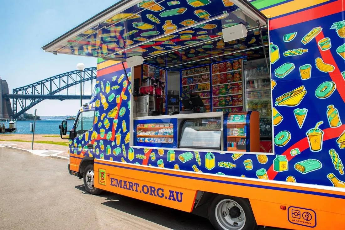 A photo of a vehicle with beautifully designed vehicle wrapped design, sitting beside the Sydney Harbour Bridge