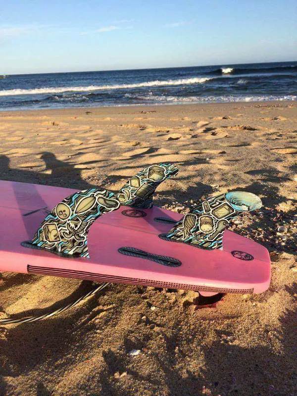 Finished surfboard fins installed in surfboard at the beach