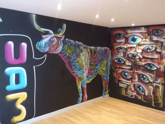 Corner mural depicting a vibrant psychedelic bull, UDM in balloon letters, and a geometric cluster of blue eyes on a black