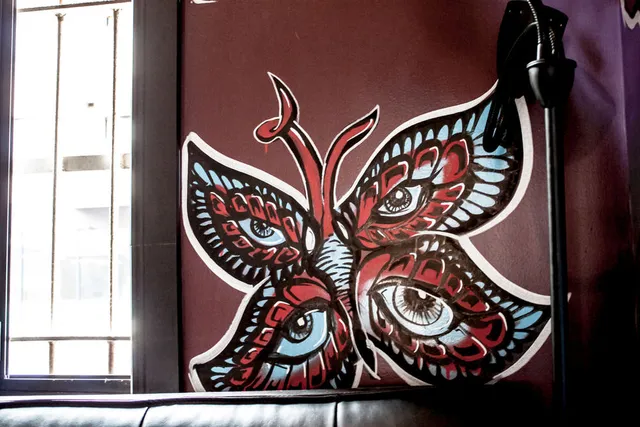 Mural of a red, black, and blue butterfly with a realistic eye on each of its four wings