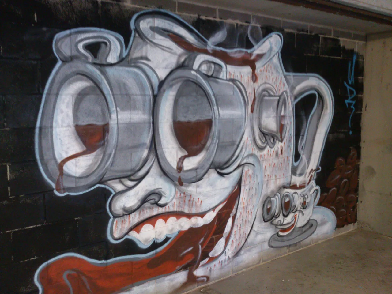 Mural of a surreal, grinning face shaped like a coffee pot with protruding coffee mug eyes and a long tongue