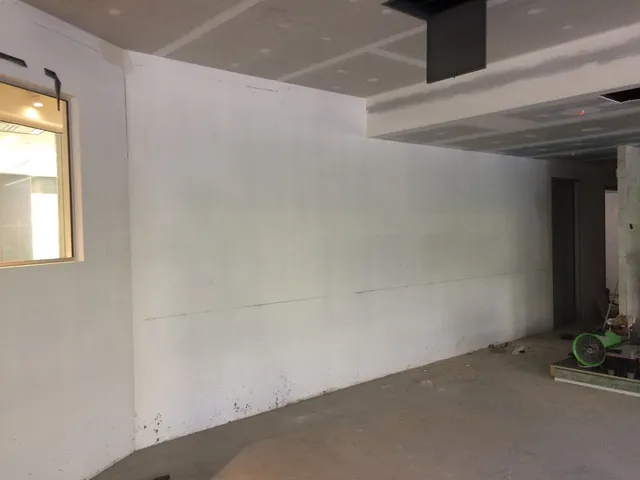 Blank white wall in an unfinished room marked with a horizontal guide line in preparation for a mural