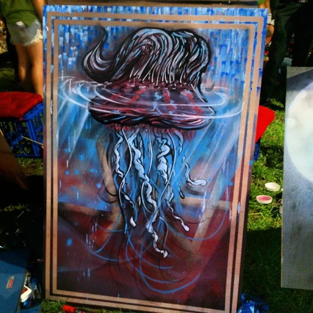 Canvas painting of a stylized jellyfish with dark hair-like tendrils emerging from blue and red water