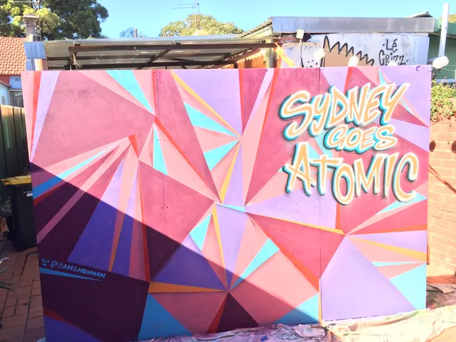 Mural featuring a pink and purple geometric background with 3D lettering reading SYDNEY GOES ATOMIC