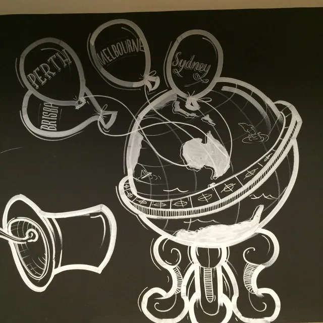 White line mural on black depicting a globe, a tin can phone, and balloons labeled with Australian cities