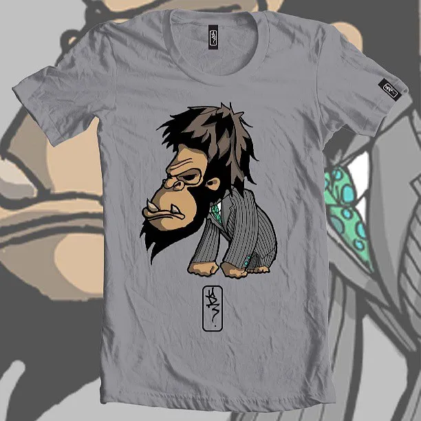 Grey t-shirt featuring an illustration of a stylized ape wearing a pinstripe suit and green tie