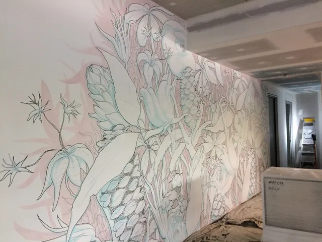 In-progress wall mural featuring dense botanical illustrations of stylized flowers and leaves with bold outlines