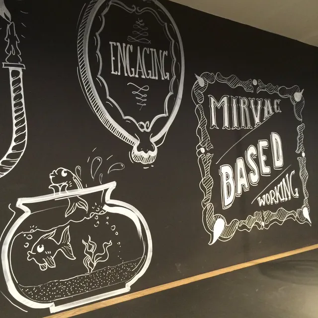 Black mural featuring white line art of a fishbowl and hand-lettered text reading Mirvac Based Working
