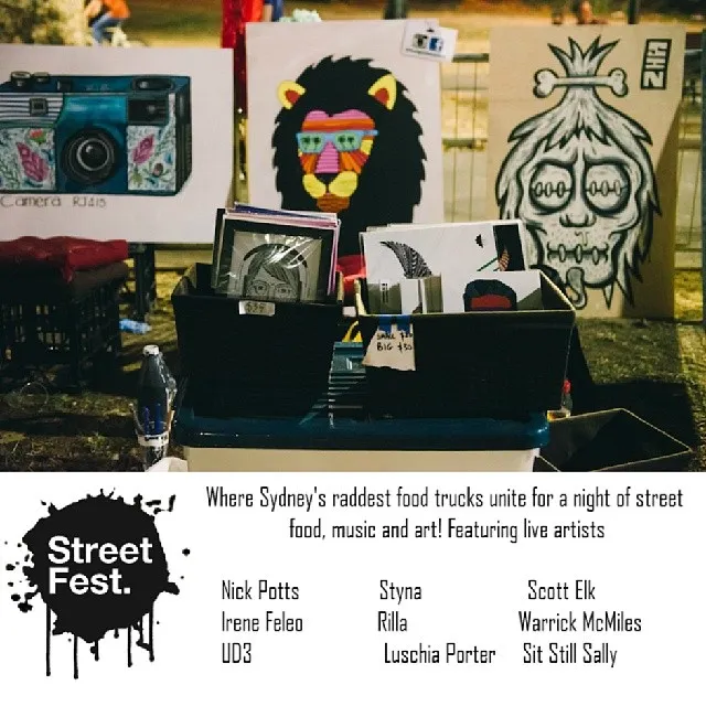 Art stall displaying paintings of a camera, lion, and skull above a Street Fest flyer featuring live artists