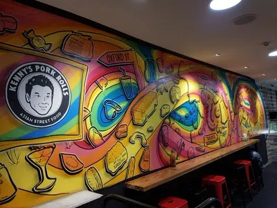 Colorful restaurant mural for Kenny's Pork Rolls featuring a wavy rainbow path, floating food and bold outlines