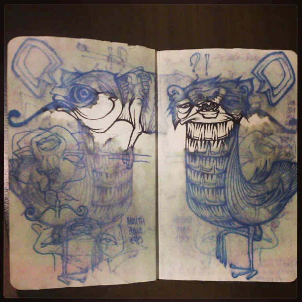 Sketchbook spread showing blue pencil and ink sketches of two surreal, grinning bird-like creatures