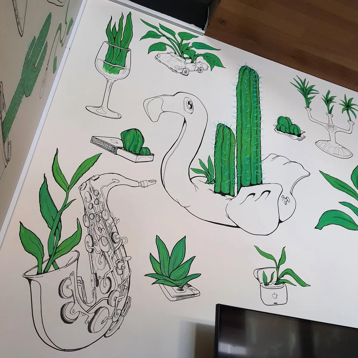Wall mural of black line-drawn objects like a saxophone and inflatable flamingo sprouting bright green plants