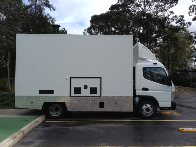 Plain white box truck with diamond plate lower skirting parked outdoors