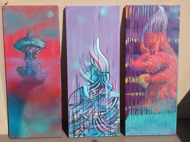 Three tall canvas paintings depicting a surreal apple core, an abstract linear tower, and a vibrant orange fox