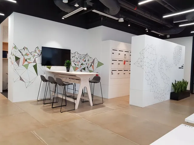 Geometric line art murals of mountains and an abstract map painted on white office walls