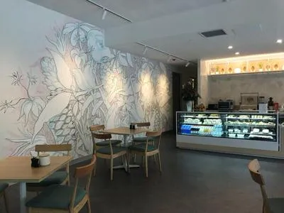 Large wall mural of stylized botanical line work in pale pastel colors inside a cafe interior