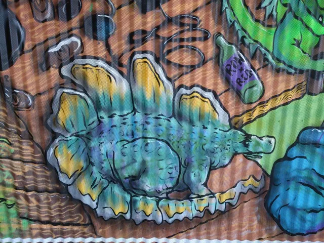 Detail of a mural on corrugated metal depicting a stylized blue and yellow stegosaurus with bold black outlines