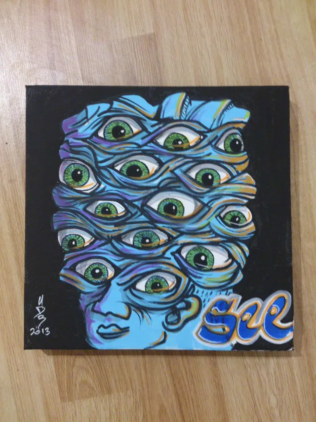 Canvas painting of a surreal blue face topped with a mass of green eyes, featuring the word See in stylized letters