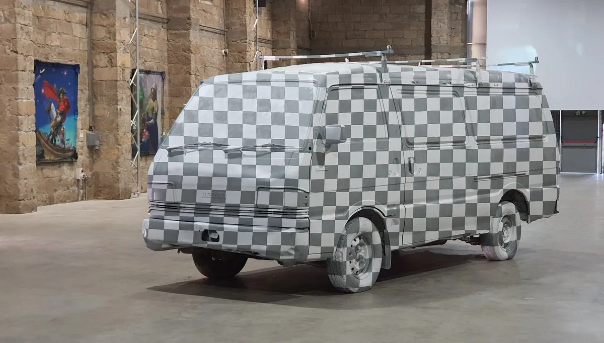 Van completely painted in a grey and white checkerboard pattern resembling a 3D texture map