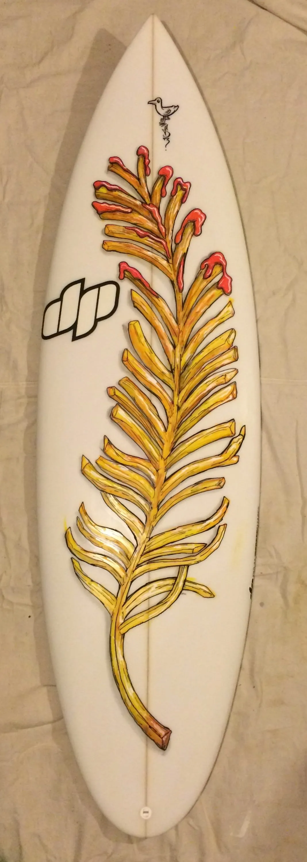 Hand-painted surfboard displaying a large feather made of french fries topped with ketchup
