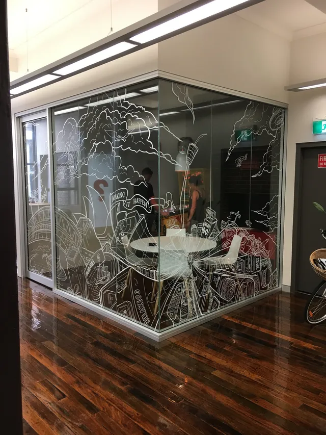 White line mural of a Sydney cityscape on the glass walls of an office meeting room