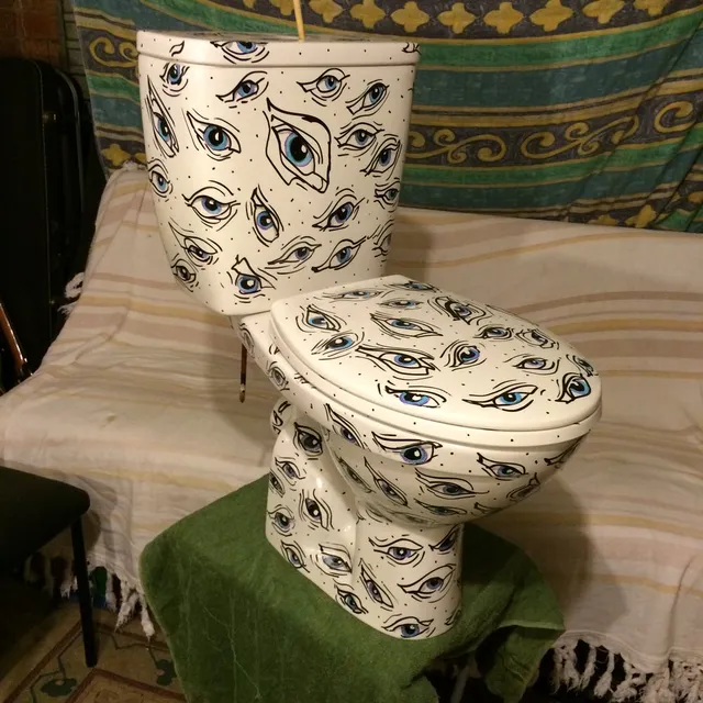 Hand-painted toilet covered in a repeating pattern of illustrated blue eyes