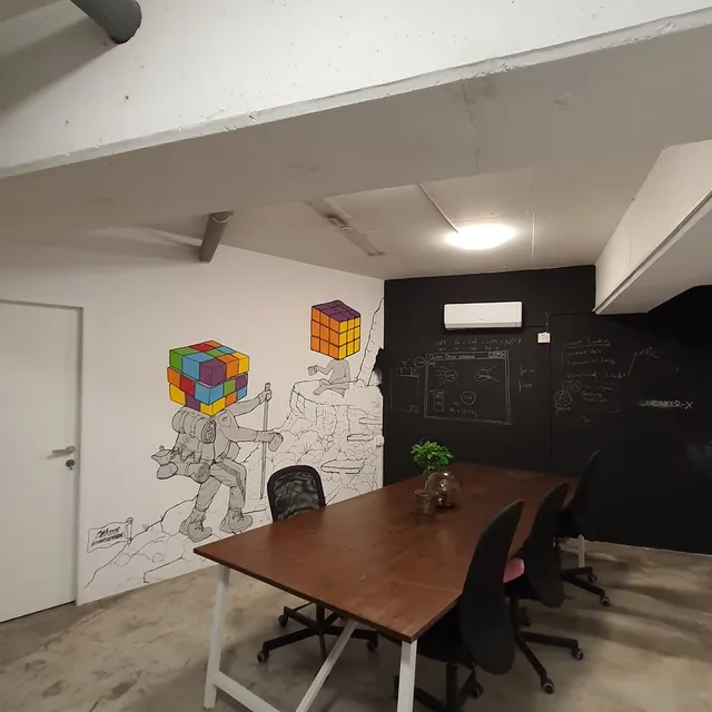 Office mural showing a line-art hiker approaching a seated figure, both with colorful Rubik's cube heads