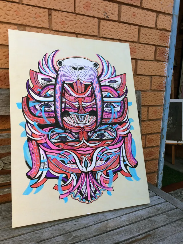 Symmetrical, psychedelic walrus mask painted on a wooden board with bold linework in pink, red, purple and light blue