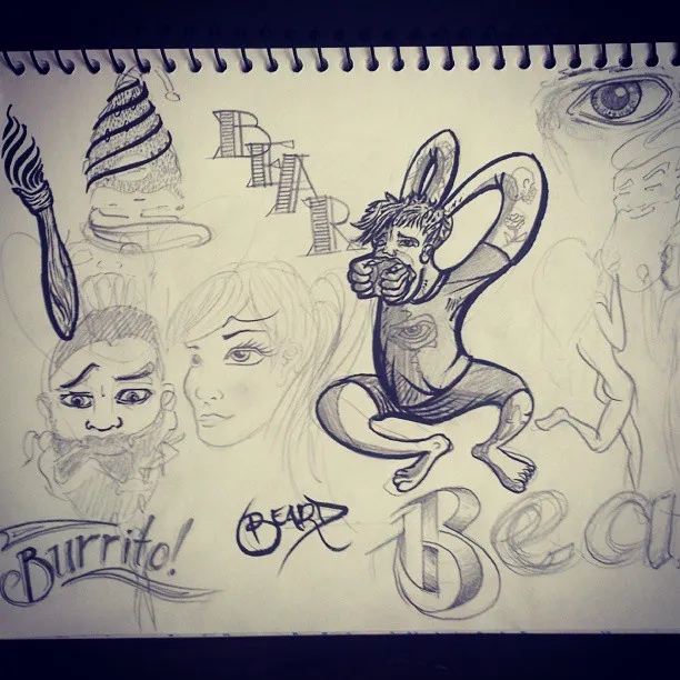 Sketchbook page with pencil and ink doodles of faces, a rabbit-eared figure eating, and lettering practice