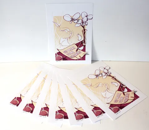 Art prints featuring an illustration of orchids, paper planes, and a scroll reading Go Make Some Stories