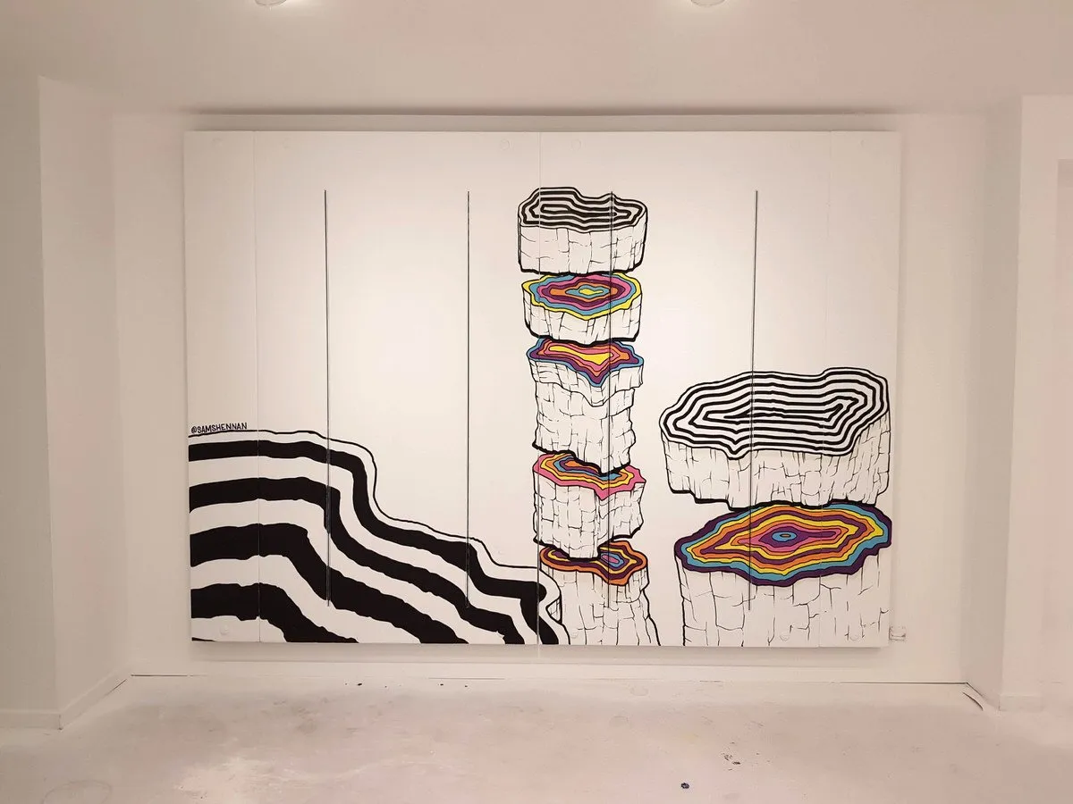 Mural depicting stacked tree trunk slices with colorful topographical rings and bold black wavy lines