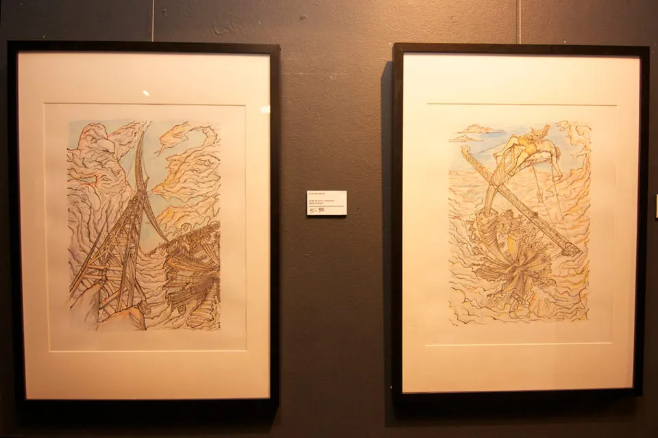 Two framed ink and watercolor drawings on a gallery wall depicting surreal structures and swirling clouds