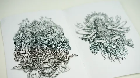 Open zine showing two detailed ink drawings of complex, symmetrical psychedelic faces