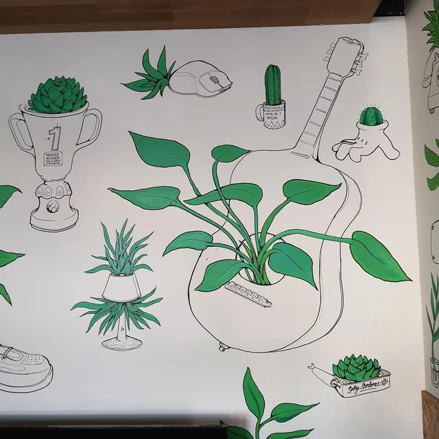 Mural featuring black line art of a guitar, trophy, and computer mouse used as planters for green foliage