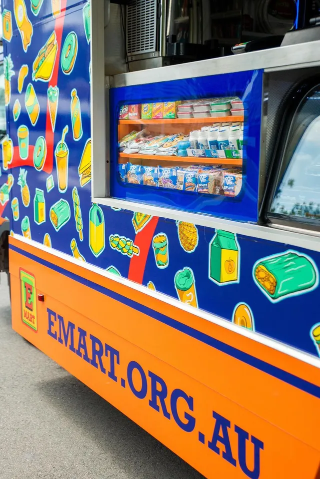 Blue and orange food truck vehicle wrap featuring bold graphic illustrations of floating snacks and drinks