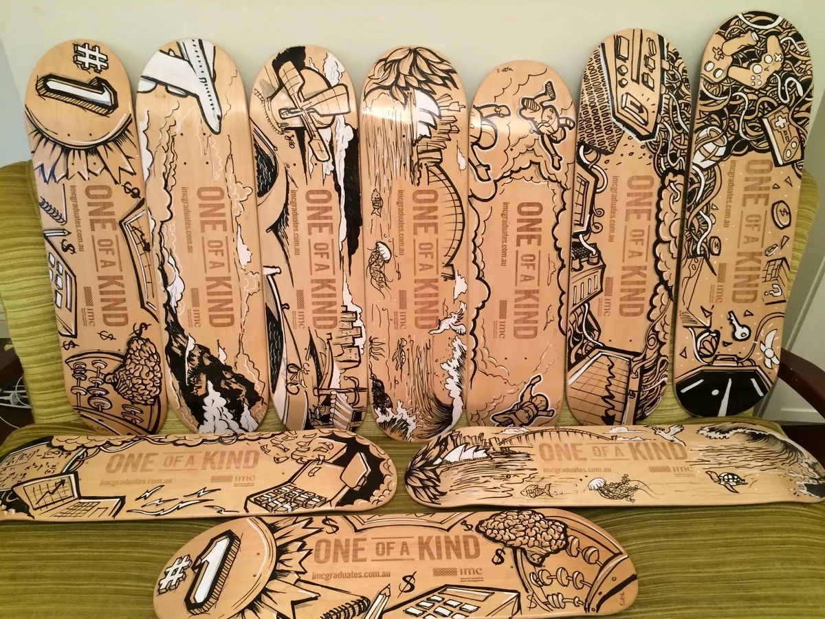 Ten wooden skateboard decks hand-painted with diverse black and white illustrations featuring bold line work