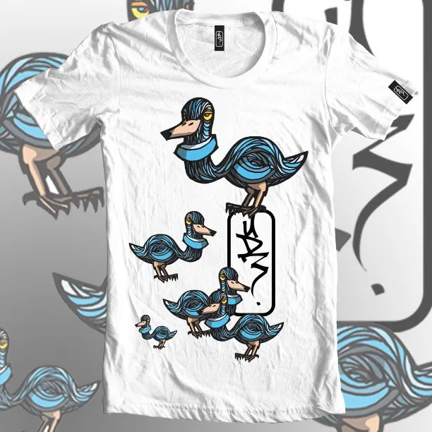 White t-shirt featuring an illustration of stylized blue birds made of bold swirling lines and a graffiti tag