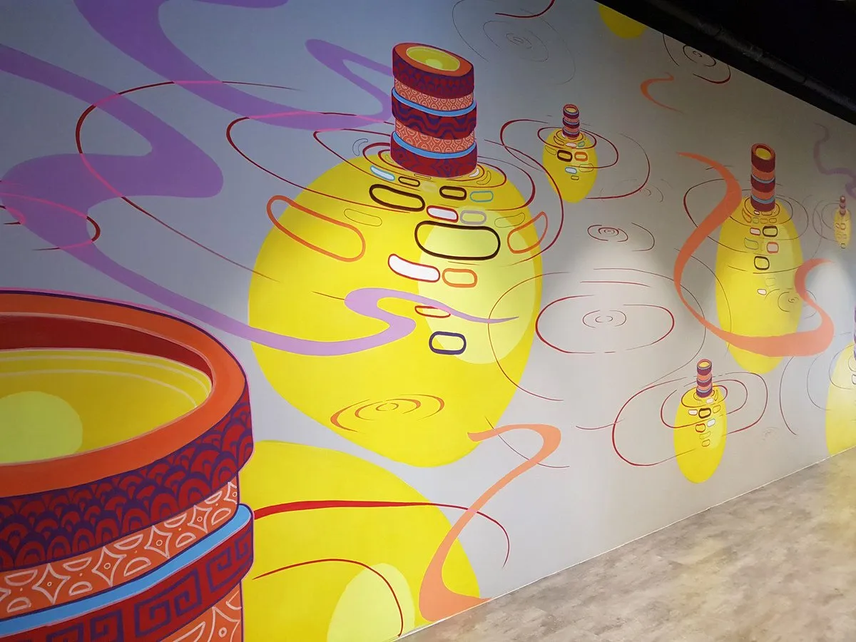 Wall mural of stacked patterned cylinders floating in red ripples with glowing yellow shapes and purple swirls