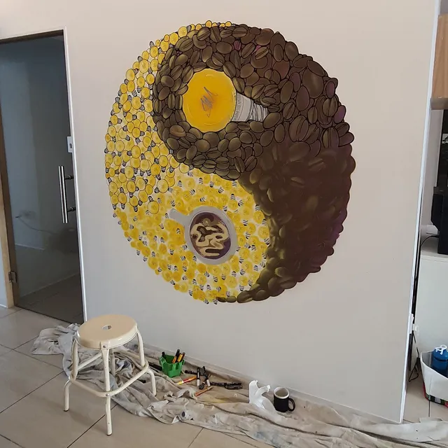 Mural of a yin-yang symbol made of coffee beans and yellow lightbulbs, featuring a coffee cup and a large lightbulb
