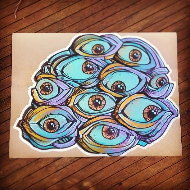 Cut-out illustration of clustered psychedelic blue and purple eyes with bold linework on brown paper