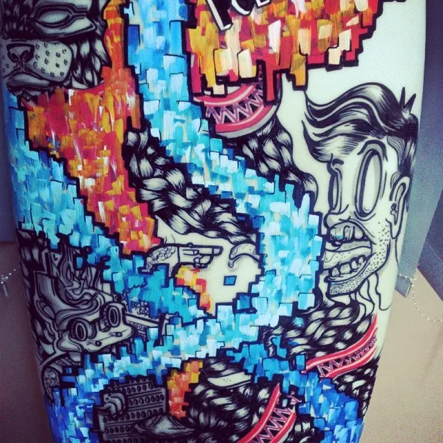 Painted surfboard with black line art of a face and dog, intersected by bright blue and orange pixelated block patterns
