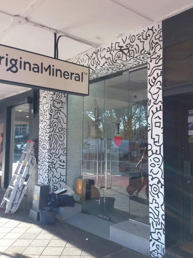 Bold black line art mural framing the glass doors of the Original Mineral storefront