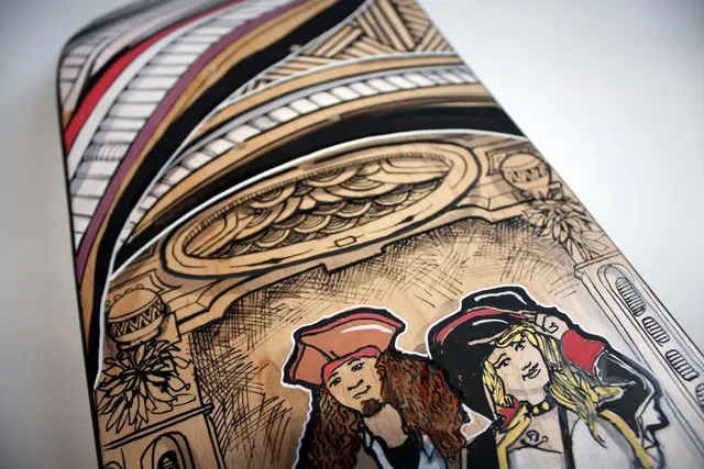 Painted skateboard deck featuring a pirate couple illustrated beneath an intricate archway with bold crosshatching