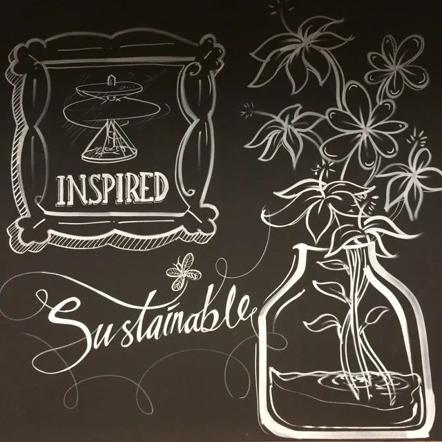 White line mural on black depicting a framed design, flowers in a water jar, and the words INSPIRED and Sustainable