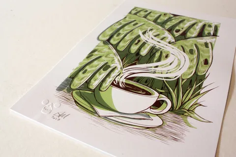 Art print illustrating a steaming white coffee cup and saucer nestled among large green tropical leaves